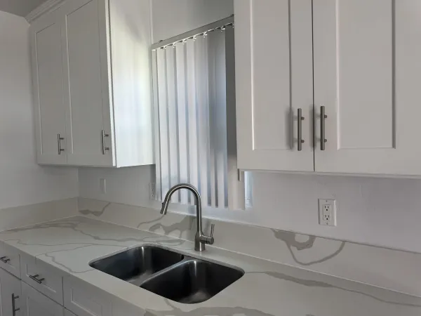 a kitchen with stainless steel appliances a sink a counter and cabinets