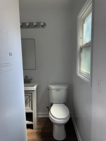 a bathroom with a toilet a sink and mirror