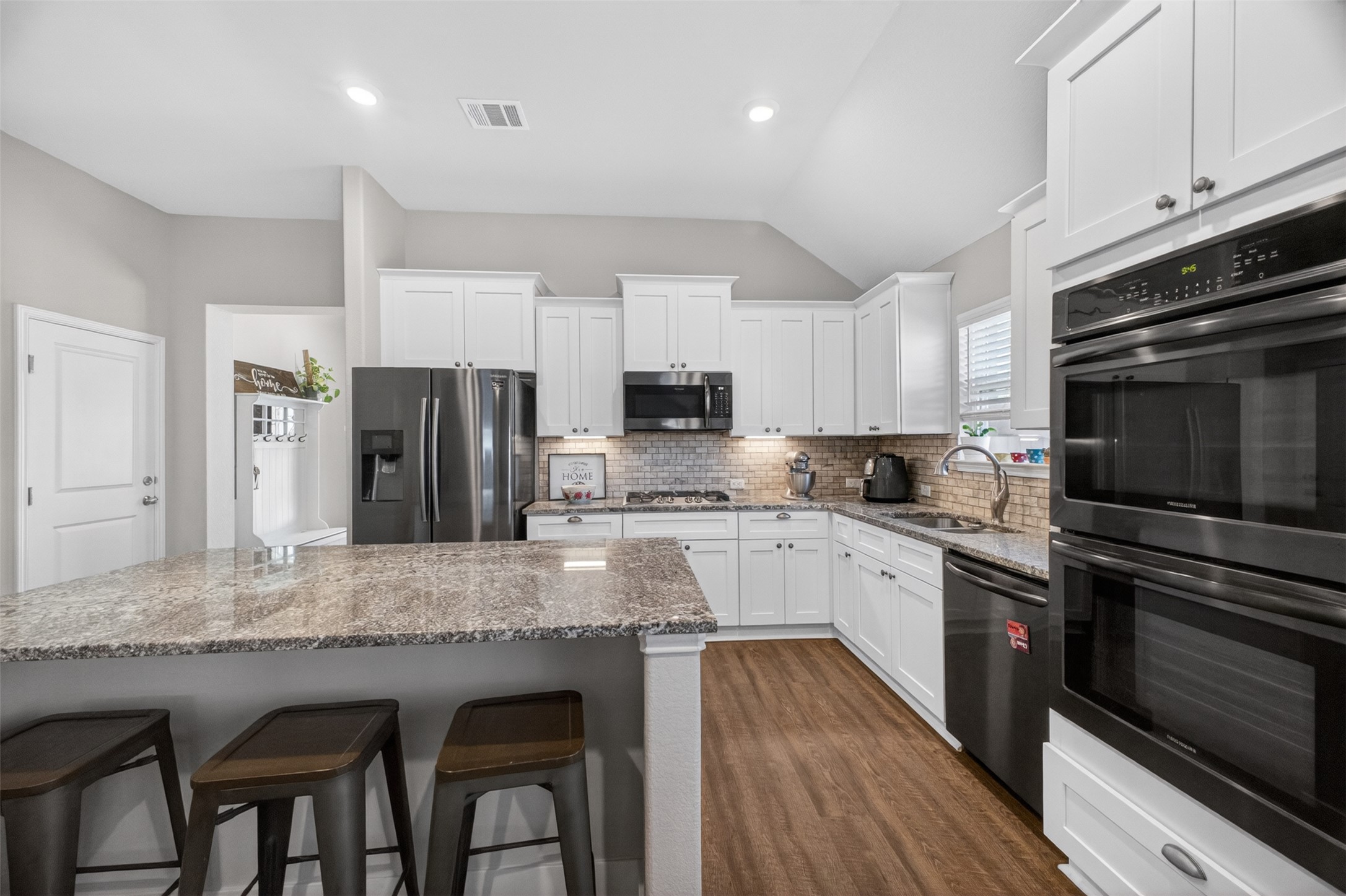 1009 Bright Star Cove Georgetown, TX 78628 - Photo 4 of 40 a kitchen with granite countertop a stove refrigerator and microwave