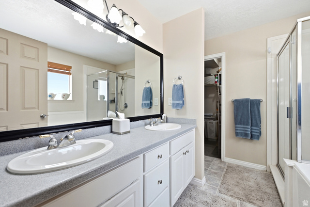 5196 Rodeo Circle Oakley, UT 84055 - Photo 25 of 57 Primary Suite with double vanity with light gray countertop, white cabinetry, and a large framed mirror