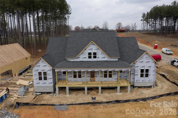 an aerial view of a house with swimming pool next to a yard