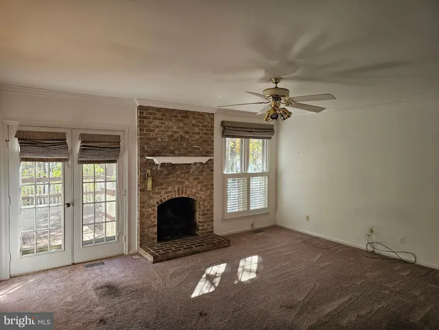 an empty room with fireplace and windows