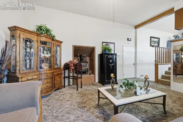 a living room with furniture a rug and kitchen view