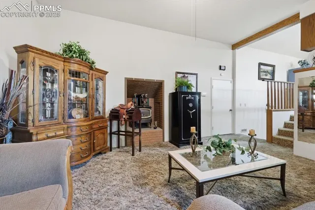 a living room with furniture a rug and kitchen view