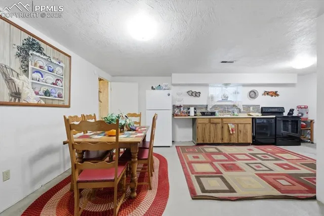 a kitchen with a dining table chairs and a view of living room