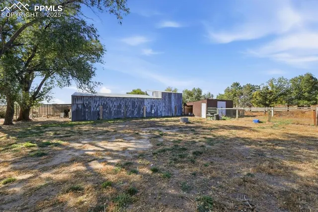 a view of a house with backyard and tree