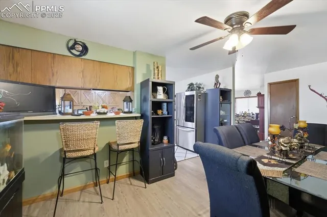 a dining room with stainless steel appliances kitchen island granite countertop furniture and a refrigerator