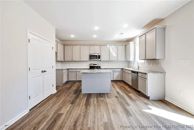 a kitchen with granite countertop white cabinets and stainless steel appliances