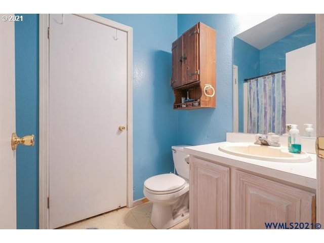32724 Old Mill Road Lebanon, OR 97355 - Photo 14 of 32 a bathroom with a toilet a sink and a mirror