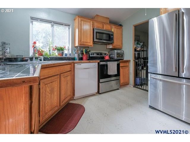 32724 Old Mill Road Lebanon, OR 97355 - Photo 26 of 32 a kitchen with stainless steel appliances granite countertop a refrigerator sink and stove