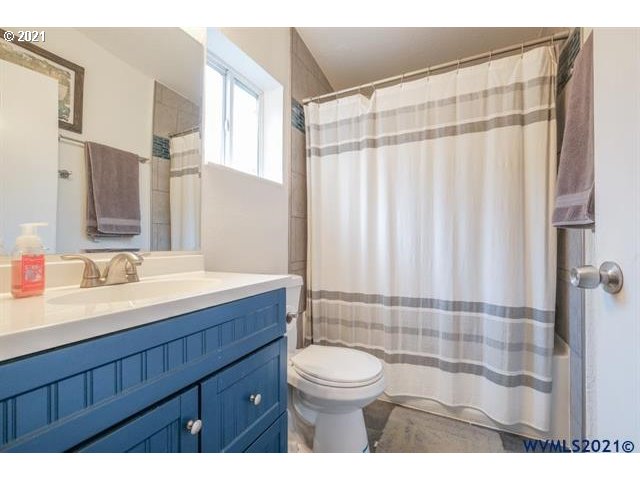 32724 Old Mill Road Lebanon, OR 97355 - Photo 30 of 32 a bathroom with a sink a toilet a shower curtain and a large mirror