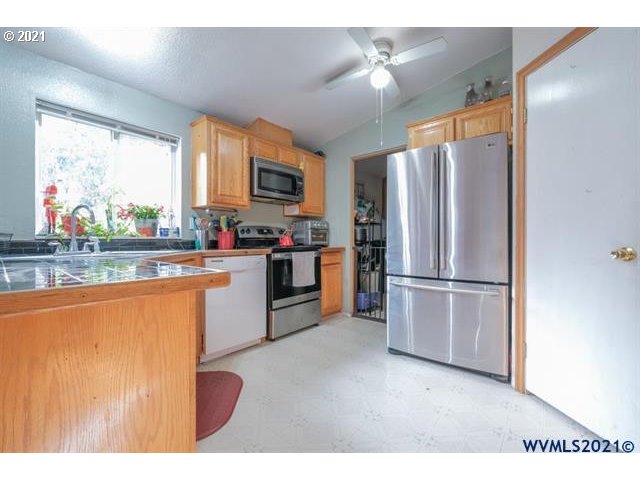 32724 Old Mill Road Lebanon, OR 97355 - Photo 6 of 32 a kitchen with stainless steel appliances a refrigerator sink and microwave
