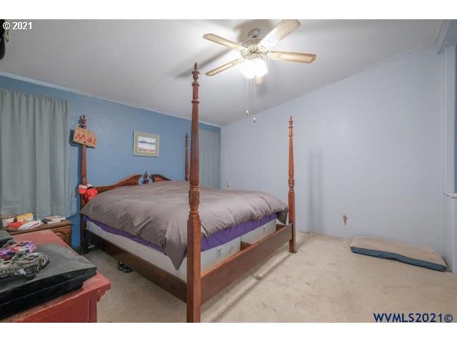 32724 Old Mill Road Lebanon, OR 97355 - Photo 8 of 32 a bedroom with a bed and a chandelier