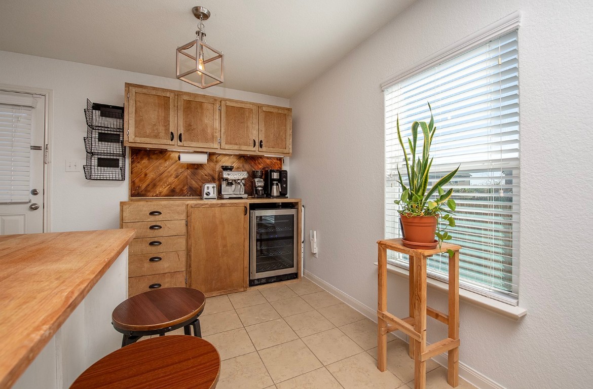 216 Millers Loop Jarrell, TX 76537 - Photo 12 of 31 Indoor dry bar featuring wooden counter, decorative light fixtures, wine cooler, tile flooring, and brown cabinetry