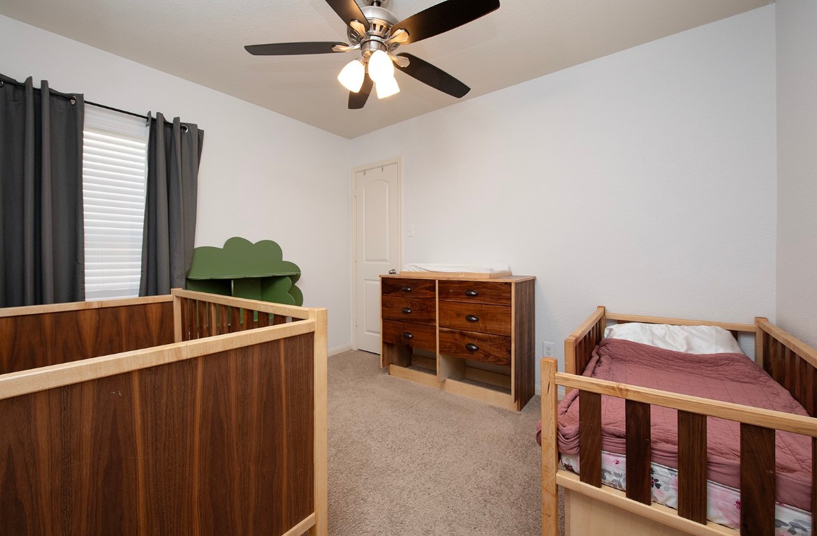 216 Millers Loop Jarrell, TX 76537 - Photo 18 of 31 Bedroom with a nursery area, carpet, and ceiling fan