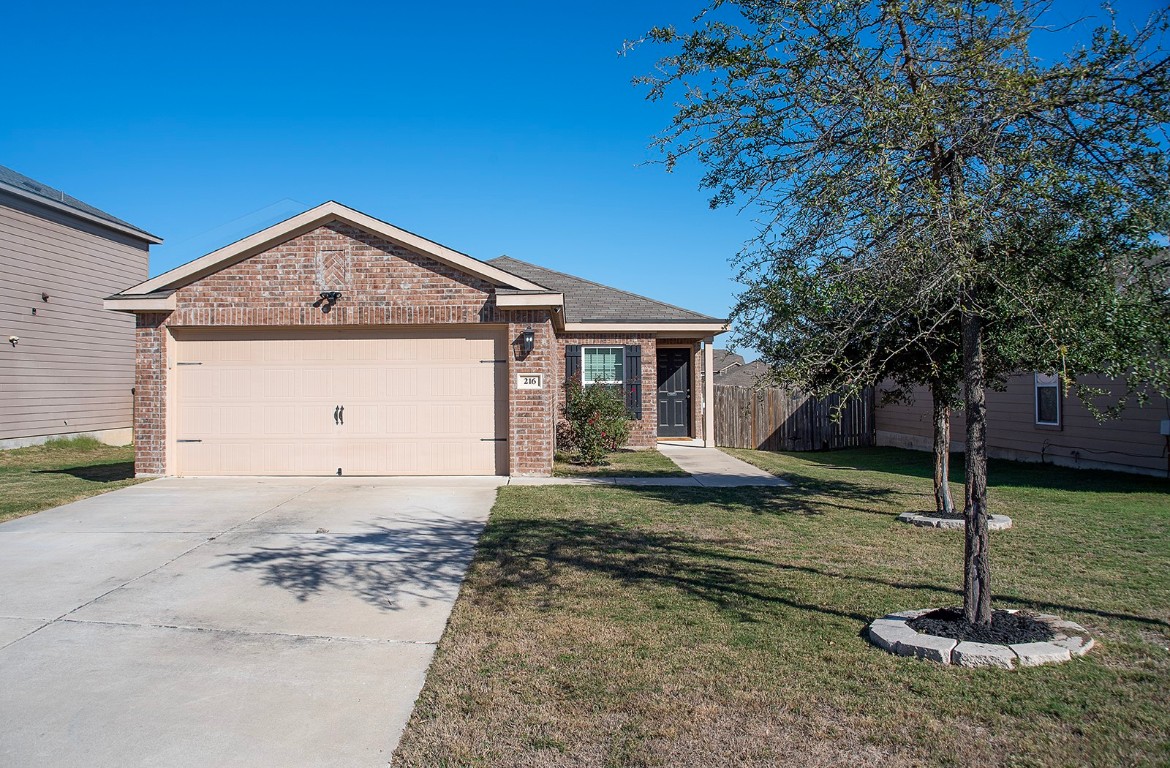 216 Millers Loop Jarrell, TX 76537 - Photo 2 of 31 Ranch-style home featuring brick siding, concrete driveway, and a garage