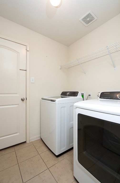 216 Millers Loop Jarrell, TX 76537 - Photo 22 of 31 Washroom with washer and clothes dryer and tile flooring