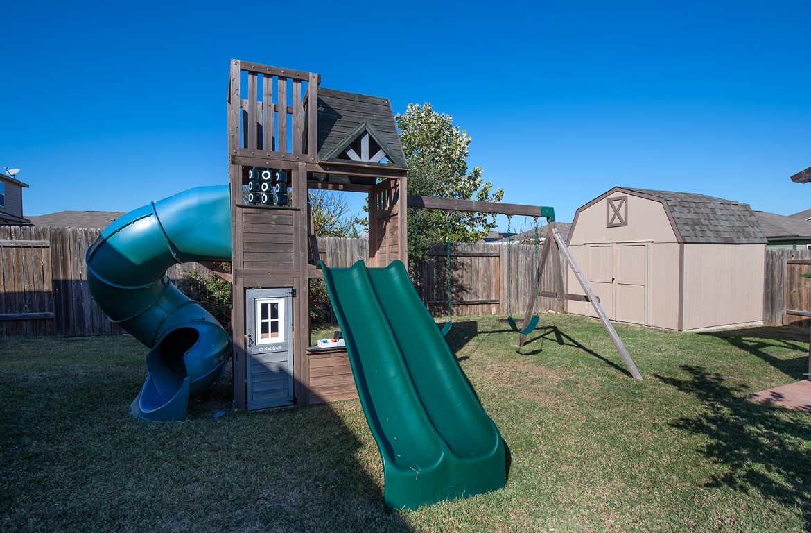 216 Millers Loop Jarrell, TX 76537 - Photo 27 of 31 View of jungle gym with a fenced backyard and a storage shed