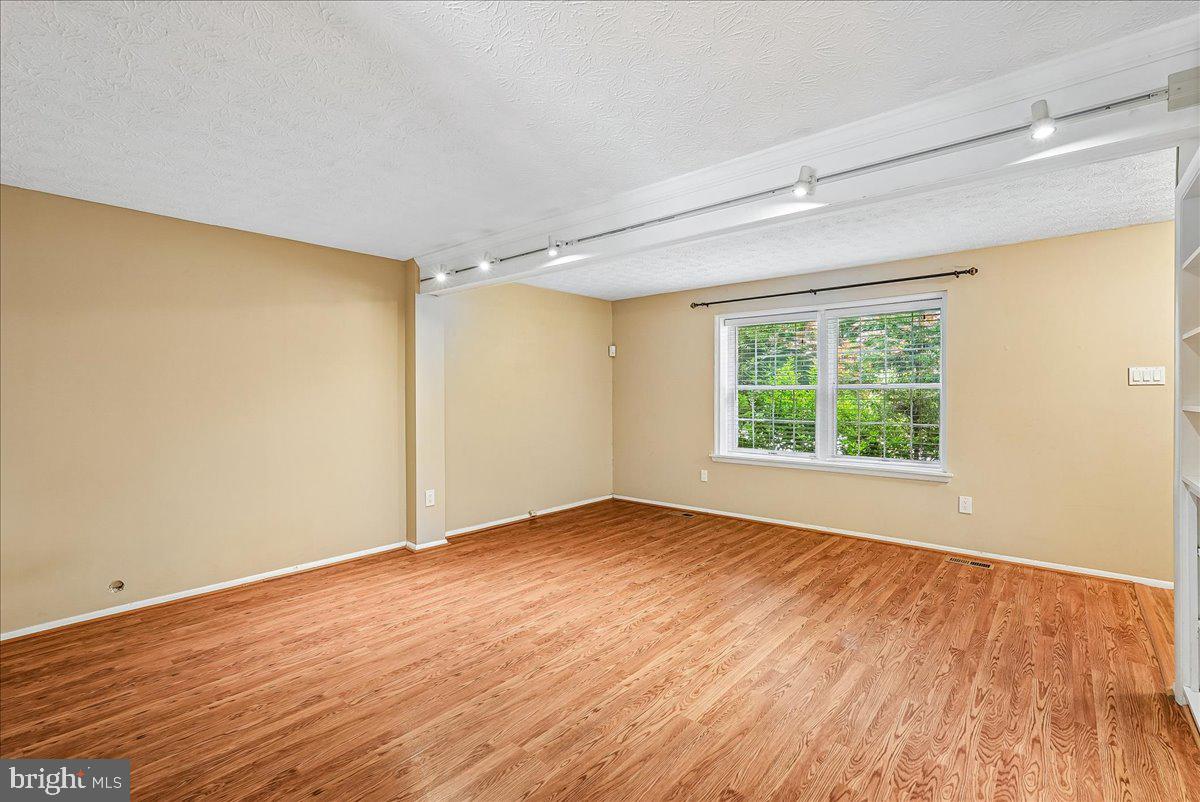 2331 Middle Creek Lane Reston, VA 20191 - Photo 14 of 78 a view of an empty room with wooden floor and a window