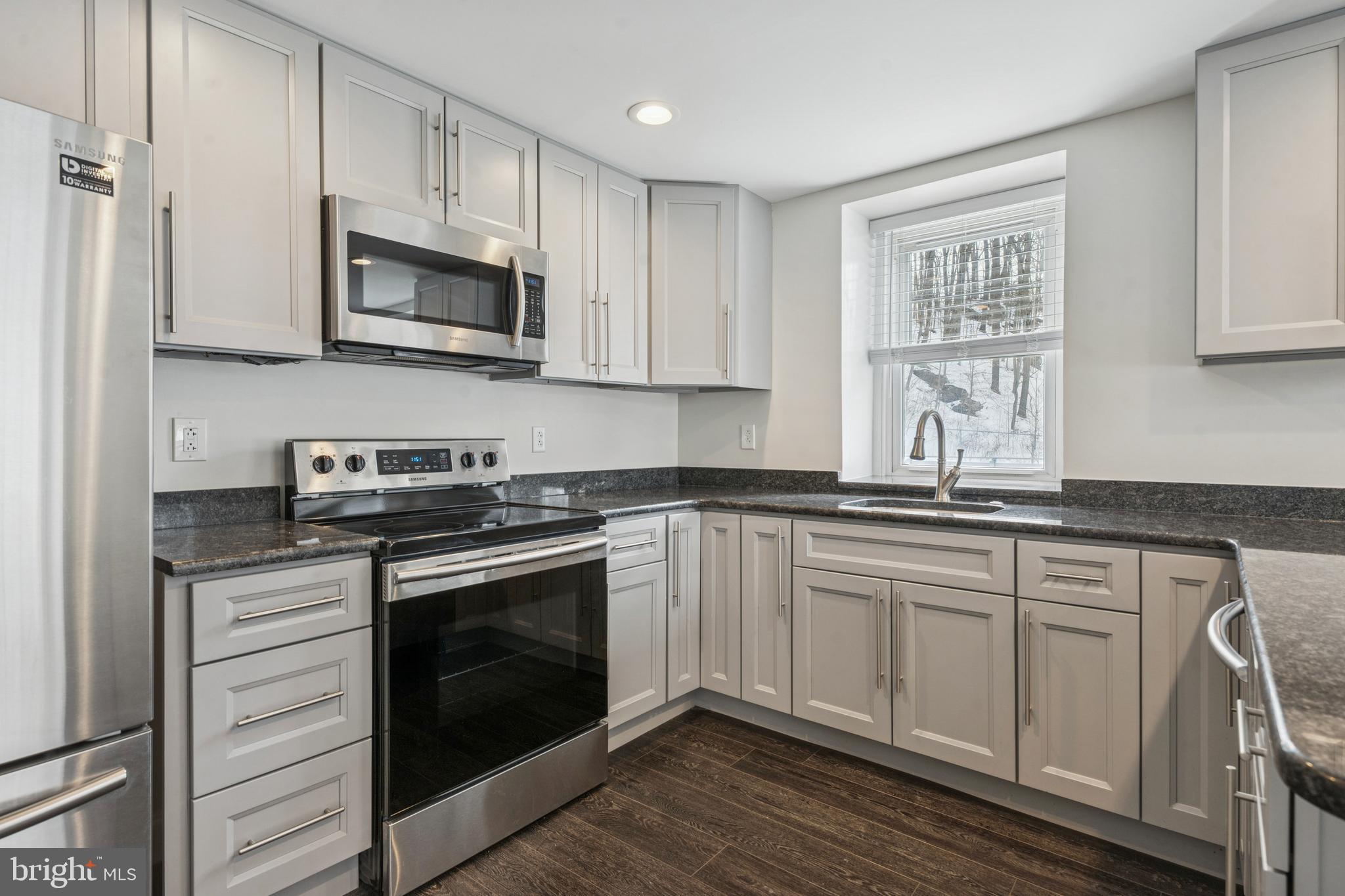 3 South Brandywine Avenue, Unit 1 Modena, PA 19320 - Photo 6 of 27 a kitchen with stainless steel appliances granite countertop a stove a sink and a microwave