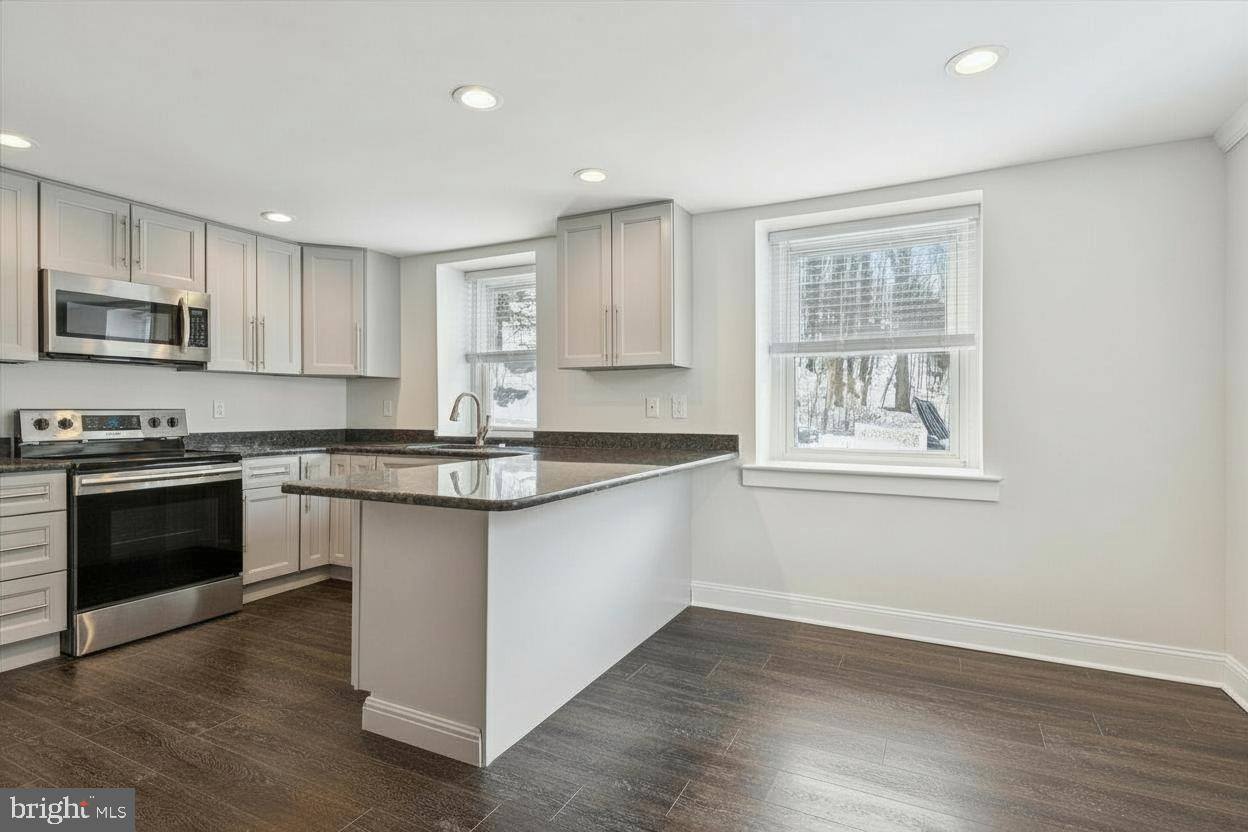 3 South Brandywine Avenue, Unit 1 Modena, PA 19320 - Photo 7 of 27 a kitchen with granite countertop wooden floors appliances and sink