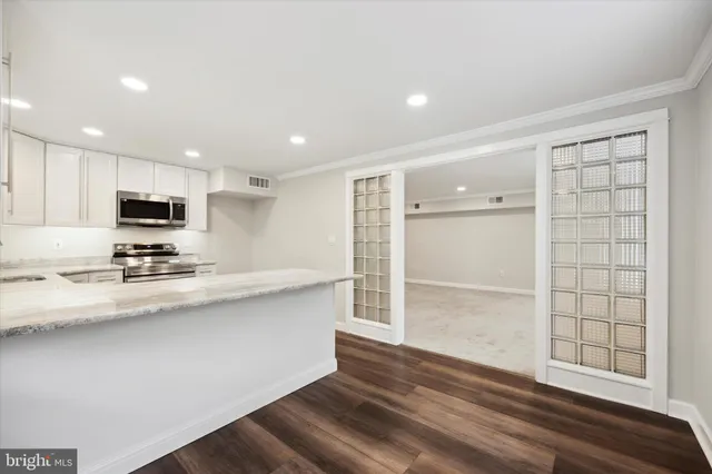 a kitchen with stainless steel appliances a sink stove and cabinets