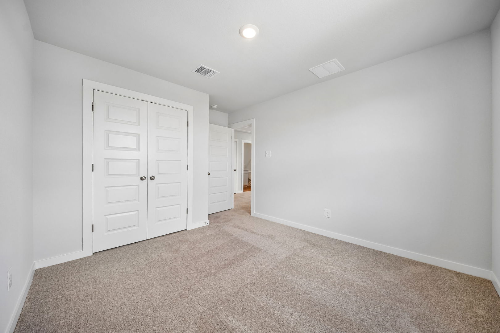 145 Hornet Street Elgin, TX 78621 - Photo 4 of 18 A well-lit bedroom featuring ample closet space and soft carpeting.