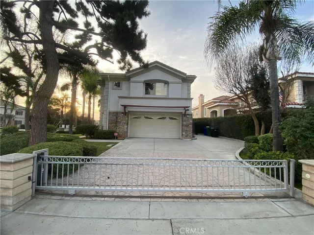 a white house with a large tree and wooden fence