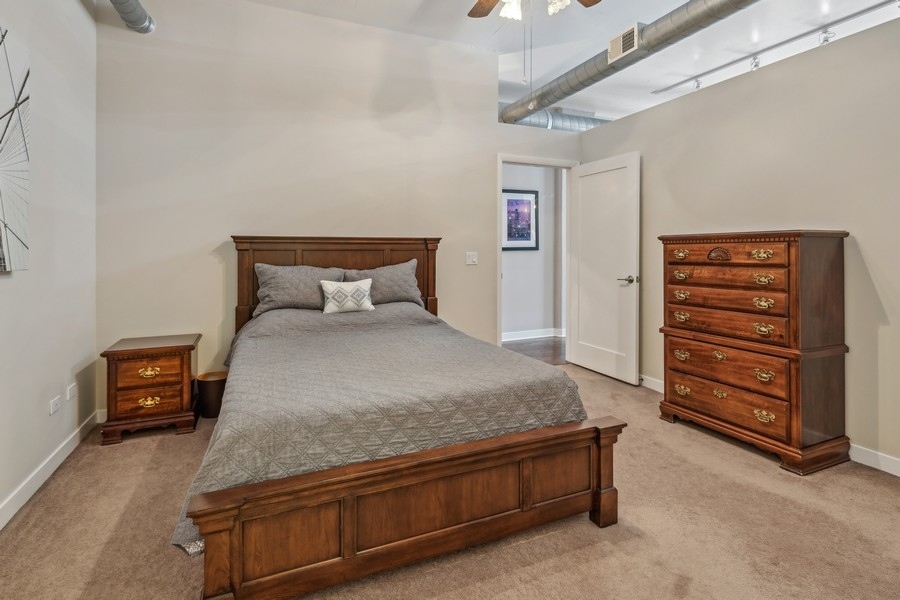 910 West Madison Street, Unit 602 Chicago, IL 60607 - Photo 11 of 15 a bedroom with a bed and a chandelier