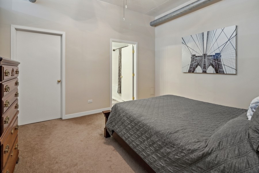 910 West Madison Street, Unit 602 Chicago, IL 60607 - Photo 12 of 15 a bedroom with a bed and a painting on the wall