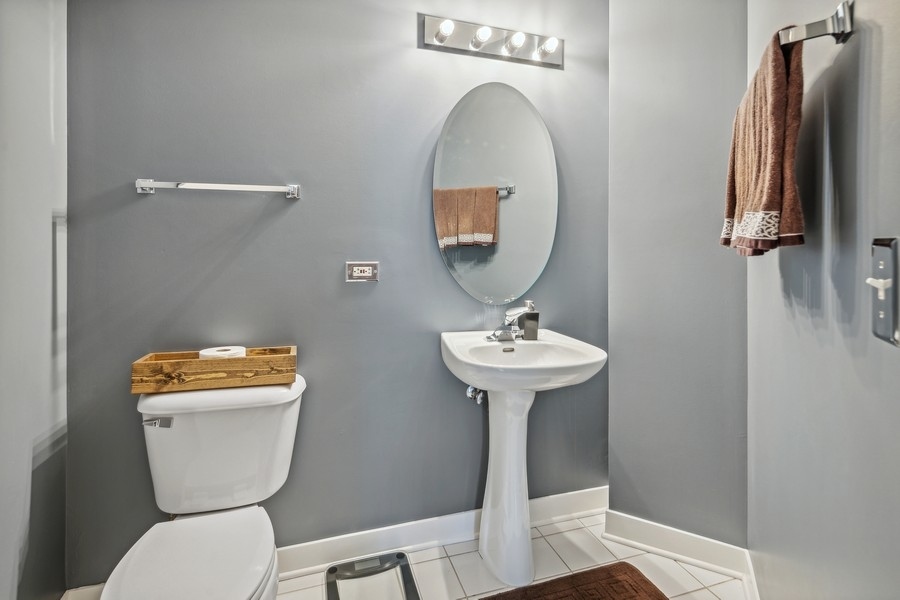 910 West Madison Street, Unit 602 Chicago, IL 60607 - Photo 14 of 15 a bathroom with a toilet sink and mirror