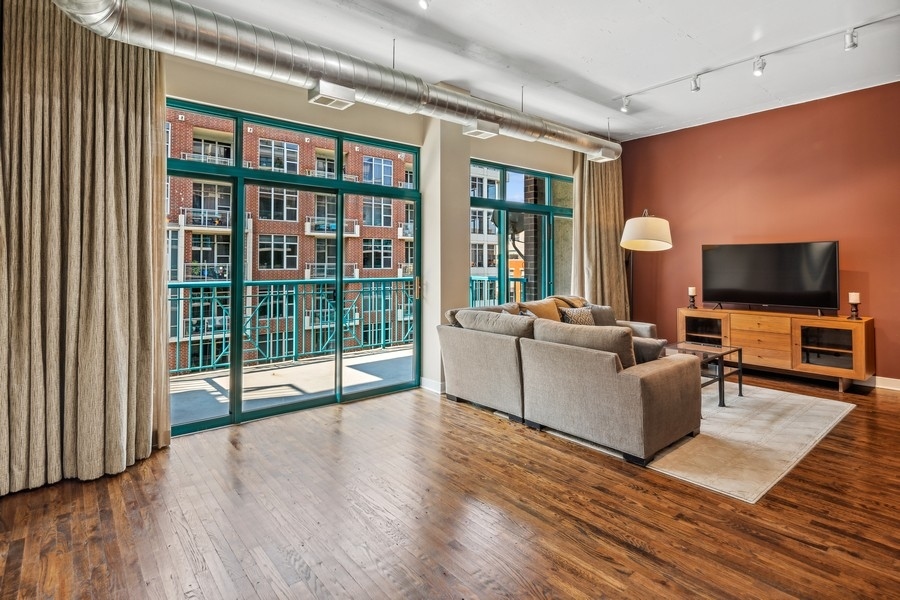 910 West Madison Street, Unit 602 Chicago, IL 60607 - Photo 5 of 15 a living room with furniture a flat screen tv and floor to ceiling window