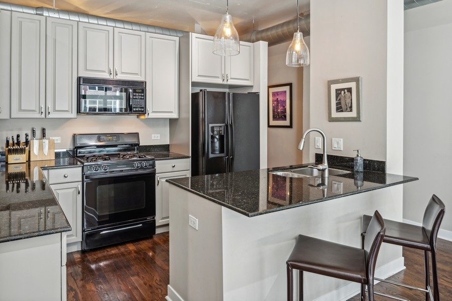 910 West Madison Street, Unit 602 Chicago, IL 60607 - Photo 7 of 15 a kitchen with granite countertop a refrigerator stove and sink
