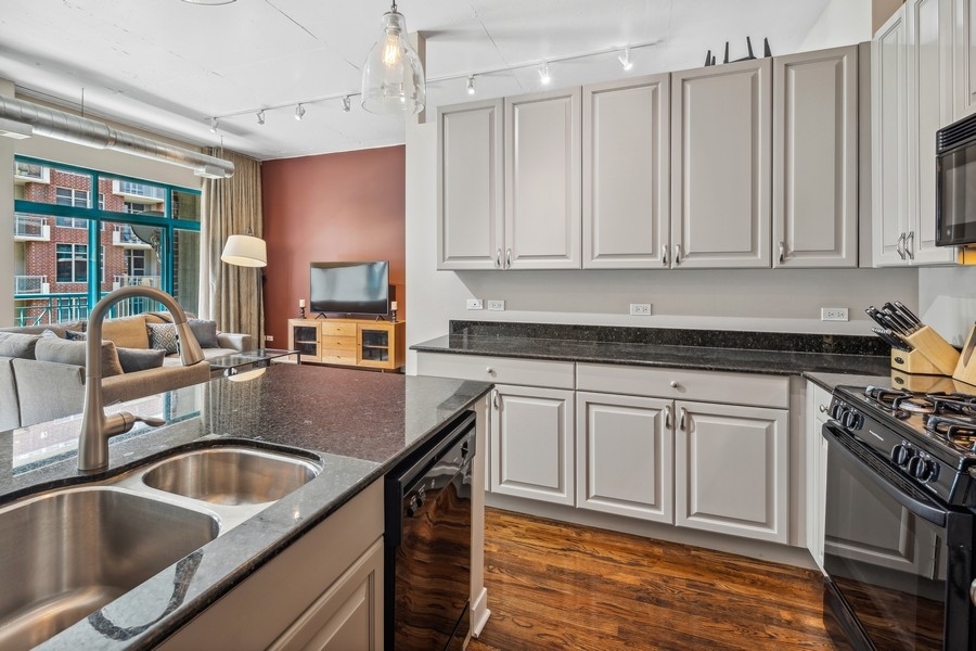 910 West Madison Street, Unit 602 Chicago, IL 60607 - Photo 8 of 15 a kitchen with granite countertop a sink a stove and cabinets