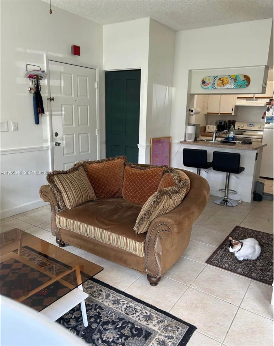 18308 Northwest 68th Avenue, Unit B Hialeah, FL 33015 - Photo 6 of 10 a living room with furniture and a rug