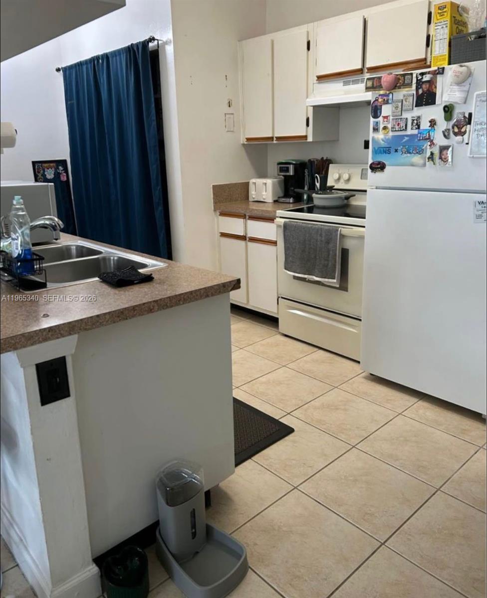 18308 Northwest 68th Avenue, Unit B Hialeah, FL 33015 - Photo 7 of 10 a kitchen with stainless steel appliances a sink stove and cabinets
