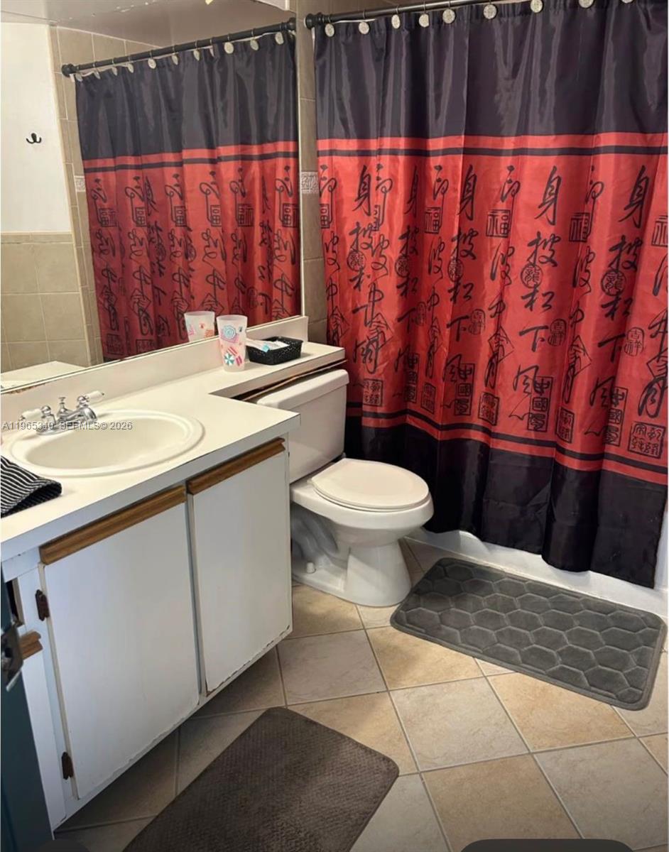 18308 Northwest 68th Avenue, Unit B Hialeah, FL 33015 - Photo 9 of 10 a bathroom with a sink a toilet and a window
