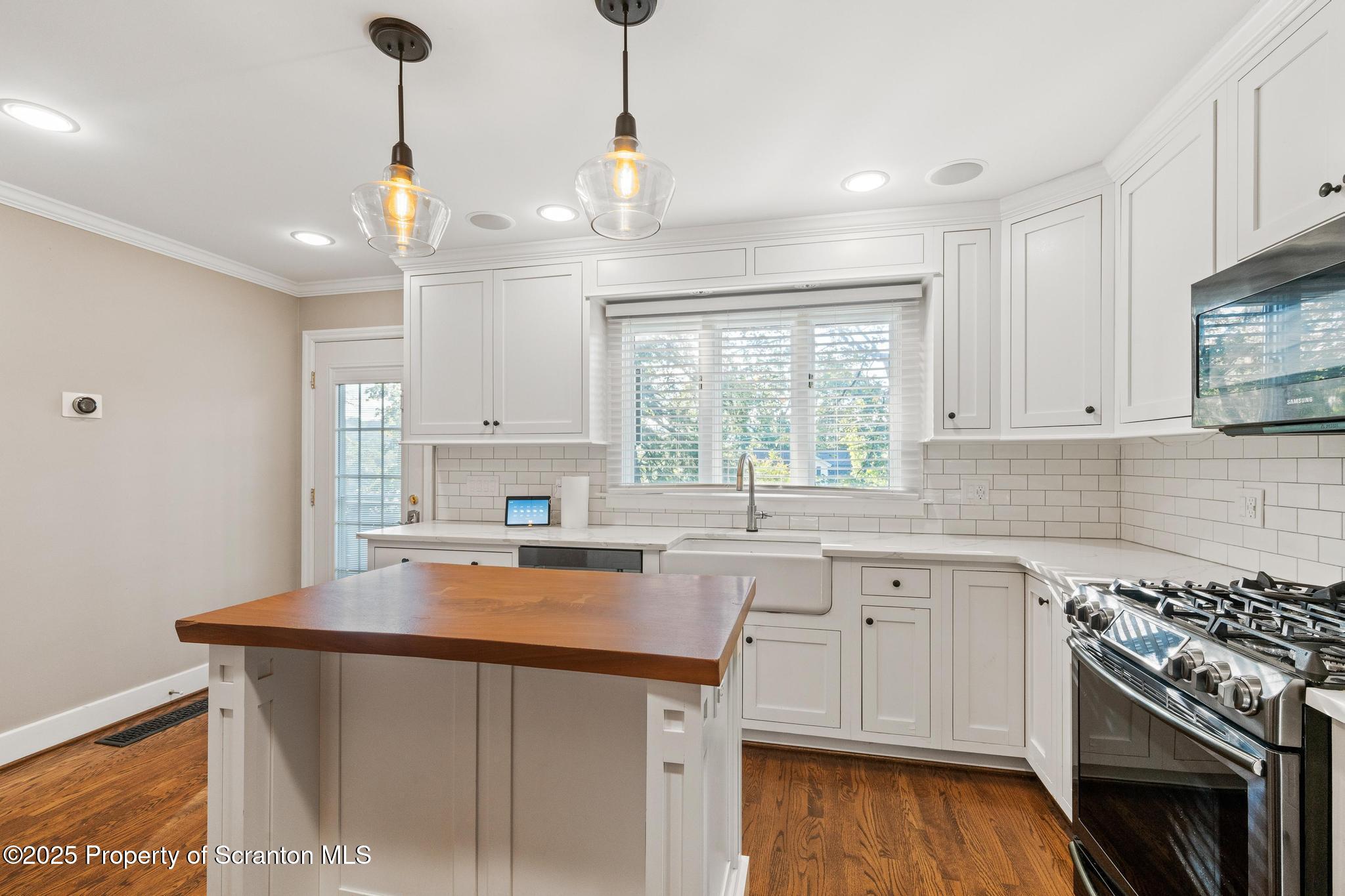 111 Upper Knapp Road Clarks Summit, PA 18411 - Photo 12 of 52 a kitchen with stainless steel appliances a stove a sink dishwasher a refrigerator and white cabinets with wooden floor