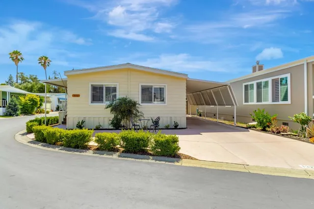 a front view of a house with a yard and potted plants