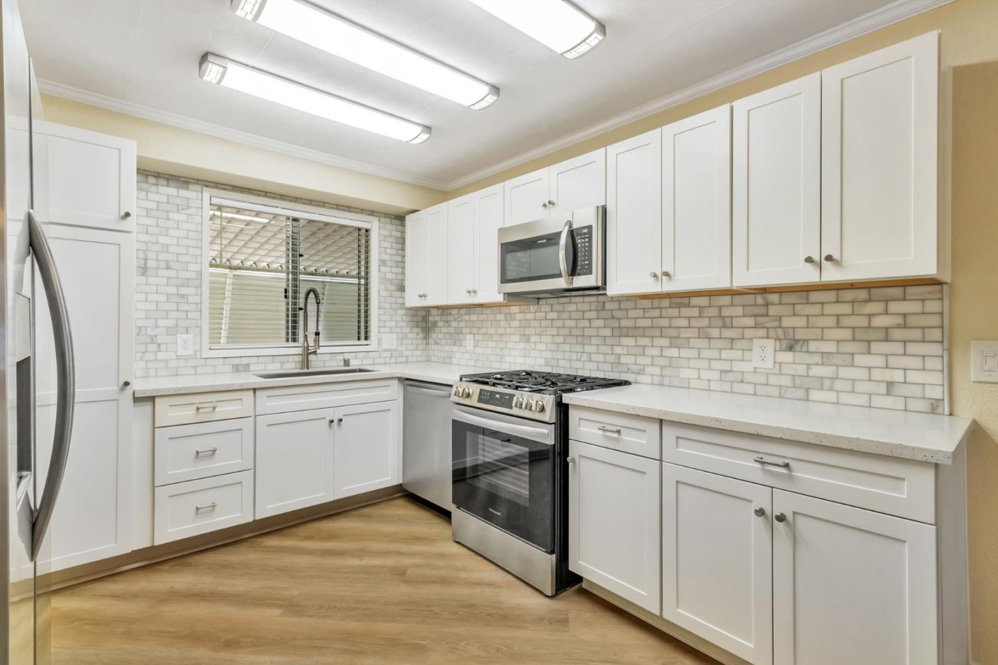 3263 Vineyard, Unit 132 Pleasanton, CA 94566 - Photo 12 of 34 a kitchen with granite countertop white cabinets sink and stainless steel appliances