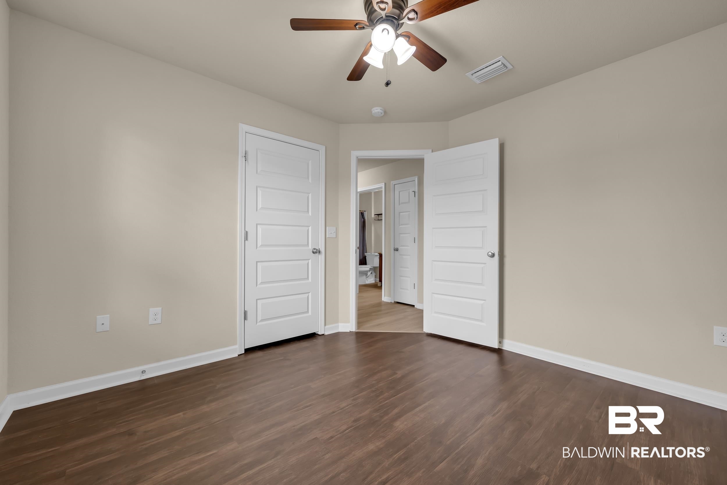 1704 Abbey Loop Foley, AL 36535 - Photo 25 of 38 Spacious room featuring wood-finish flooring, light neutral walls, and white trim