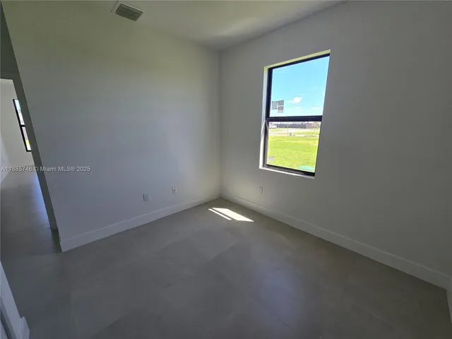 a kitchen with granite countertop a sink and white cabinets