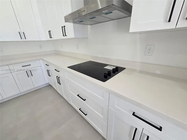 a kitchen with a sink a microwave and cabinets