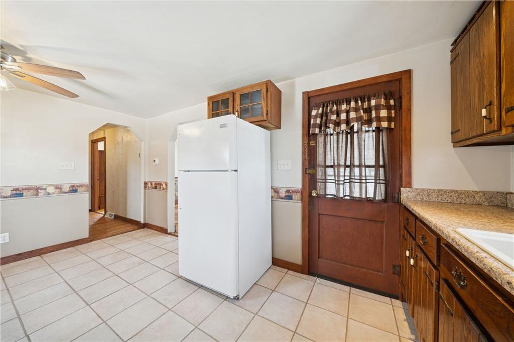 823 Arbor Lane Mount Pleasant, PA 15666 - Photo 6 of 37 a kitchen with a refrigerator a stove top oven and cabinets