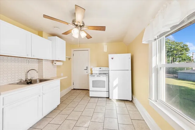 a kitchen with a sink a refrigerator and cabinets