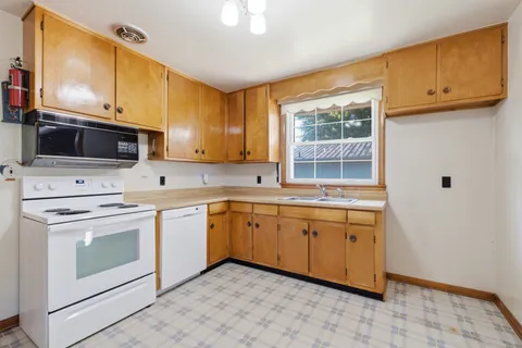 a kitchen with stainless steel appliances granite countertop a stove a sink and a microwave