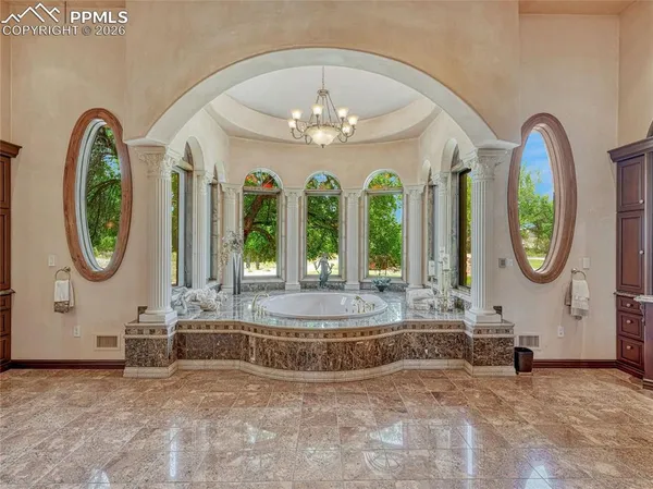 a view of a couches with a chandelier in big room