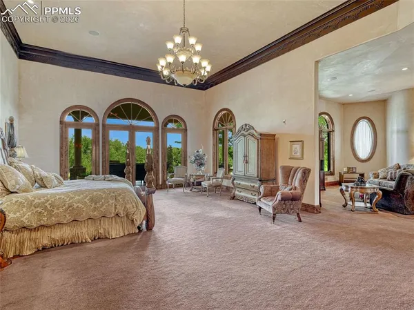 a spacious bedroom with bed and a large mirror