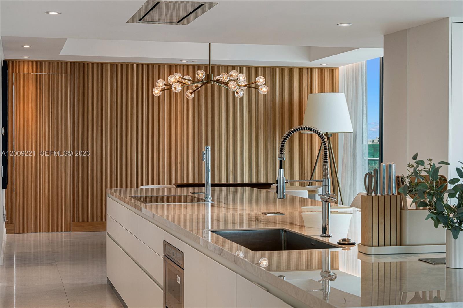 9349 Collins Avenue, Unit 801 Surfside, FL 33154 - Photo 16 of 59 a kitchen with a sink and a large mirror