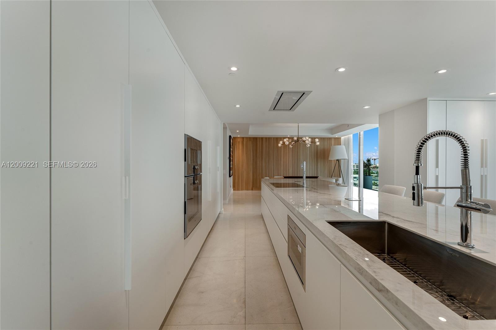 9349 Collins Avenue, Unit 801 Surfside, FL 33154 - Photo 17 of 59 a large kitchen with a large counter top a sink stainless steel appliances and cabinets